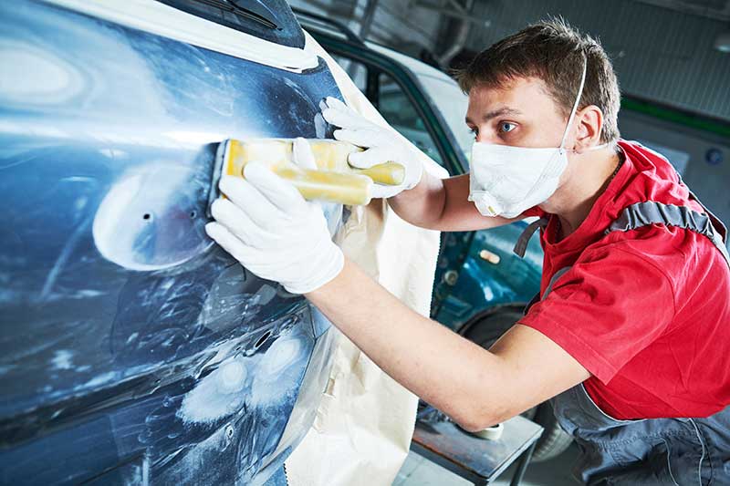 Automechaniker Schleifen der Karosserie